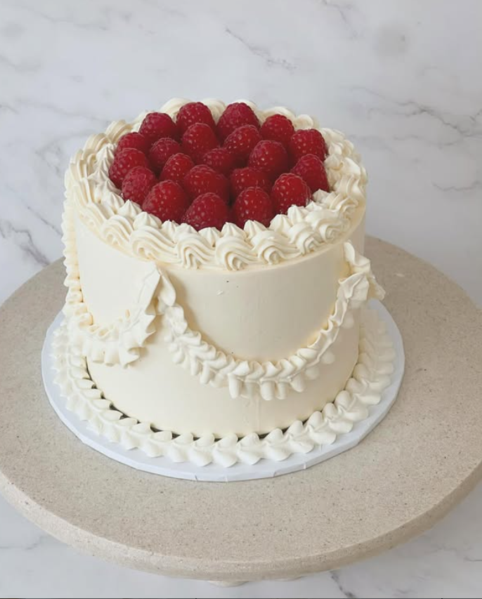 Lambeth-style ivory celebration cake topped with fresh raspberries